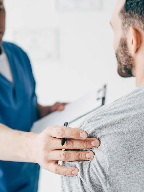 Denver chiropractor examining a shoulder