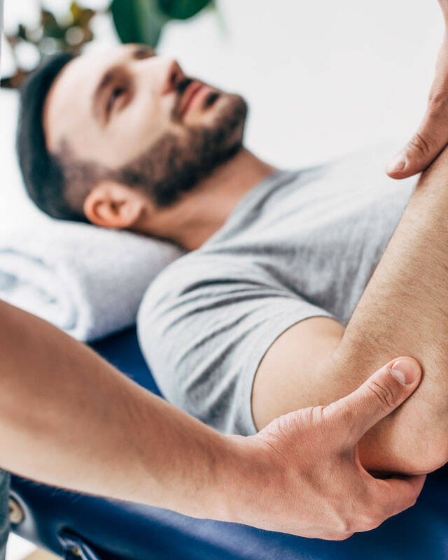 Denver chiropractor examining elbow