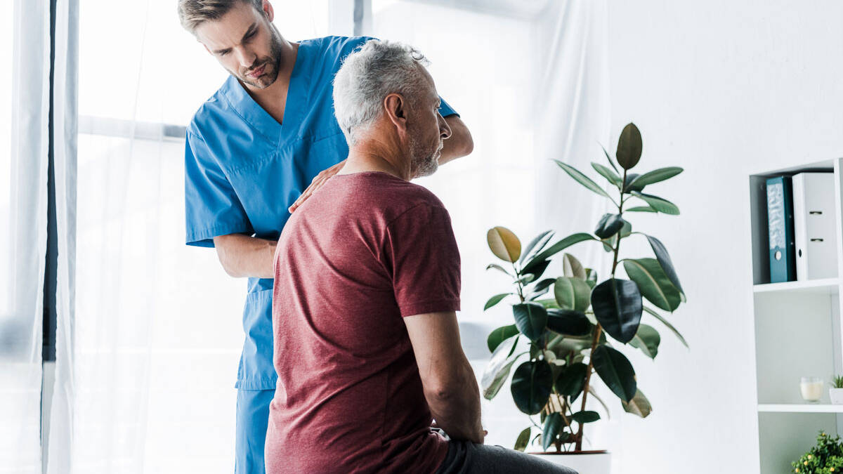 Male chiropractor in Denver examining patient