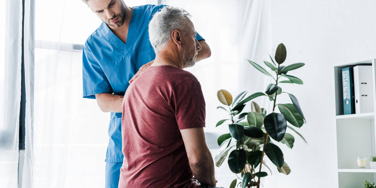 Male chiropractor in Denver examining patient